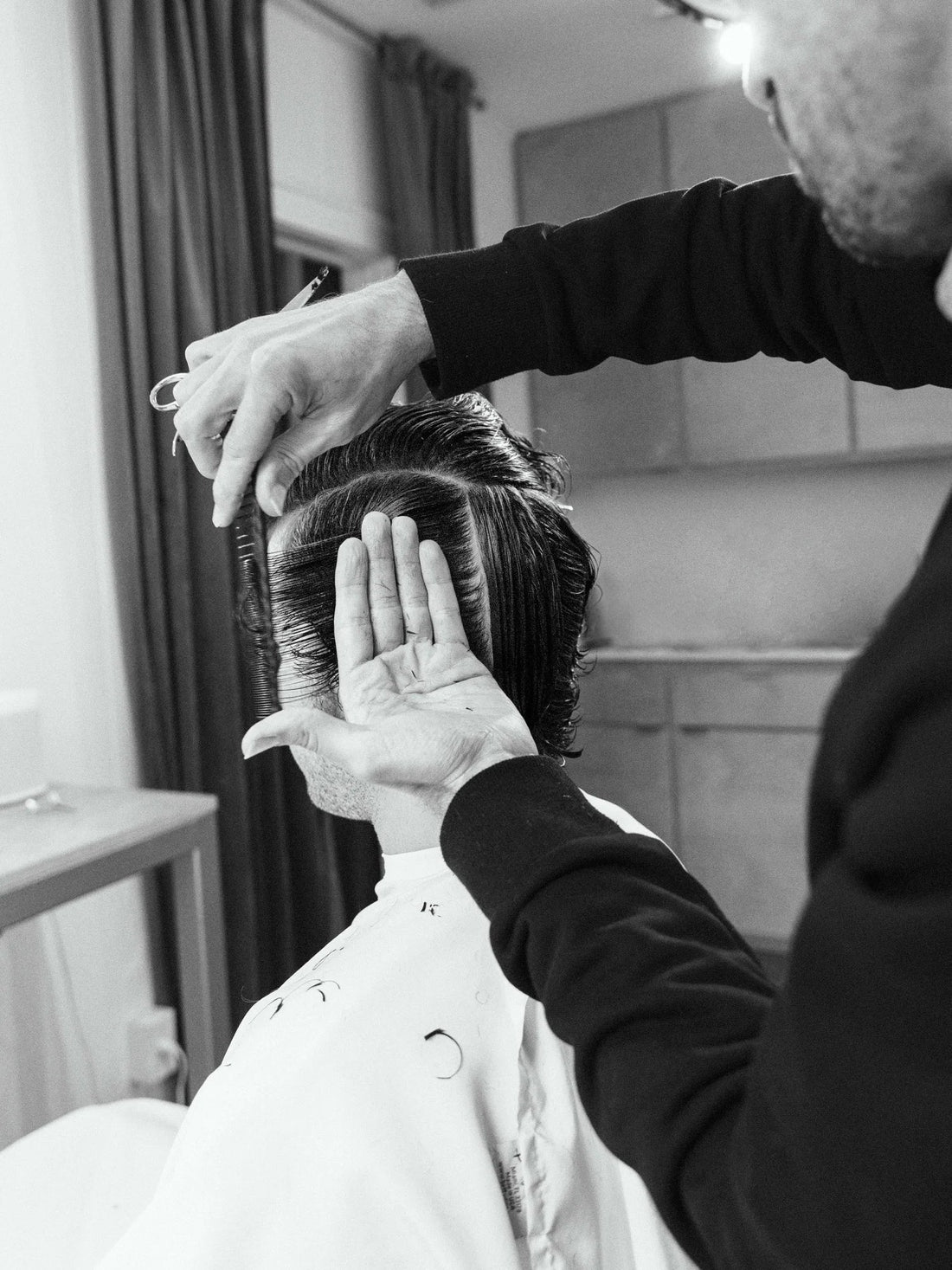 Barber performing a precise scissor haircut on a client at By Hand Barber in Bouldin Creek, Austin, TX.
