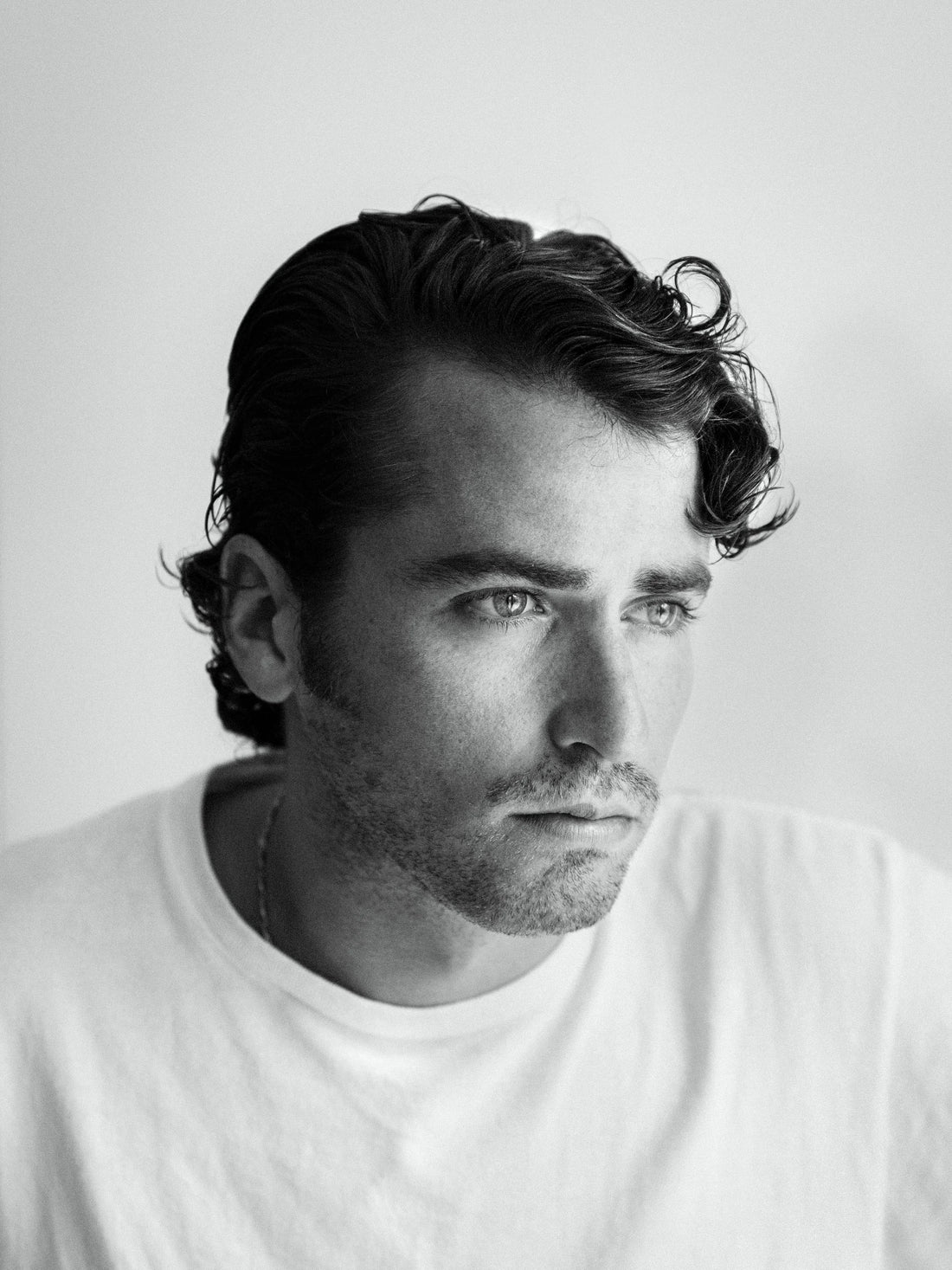 Man with styled haircut in black and white portrait at By Hand Barber, South Austin barber shop.