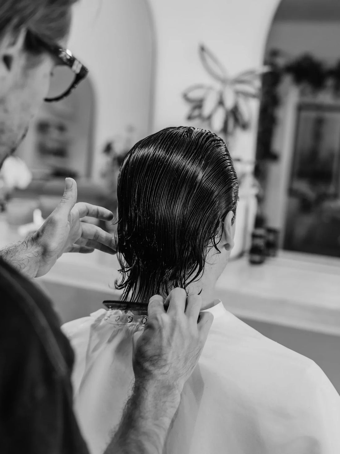 Barber shaping a men’s haircut with scissors, focusing on natural texture and clean lines in a South Austin barbershop.